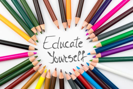 Colouring pencils in circle arrangement with message Educate Yourself, education concept