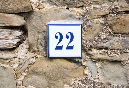 Ceramic number twenty two on the grey stone wall