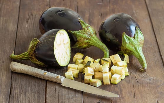 Fresh Raw eggplants with knife on the wood background