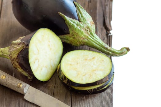 Fresh Raw eggplants with knife on the wood background