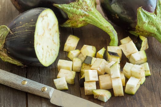 Fresh Raw eggplants with knife on the wood background
