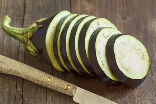 Fresh Raw eggplants with knife on the wood background