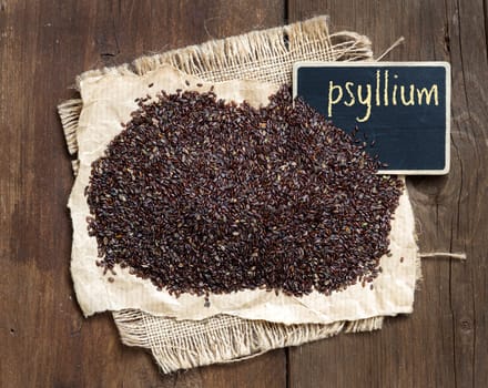 Psyllium seeds with a small chalkboard on wooden background