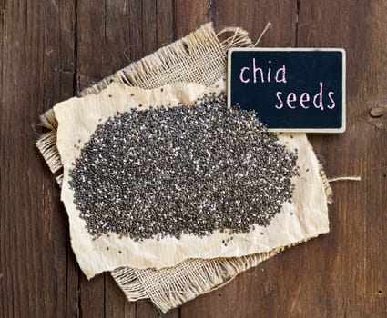 Chia seeds with small chalkboard on wooden background
