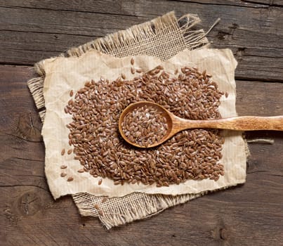 Flax seeds with a spoon on a wooden table