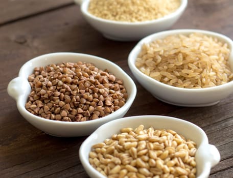 Cereals in bowls close up on wooden background