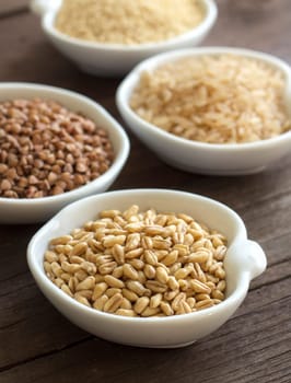 Cereals in bowls on wood close up