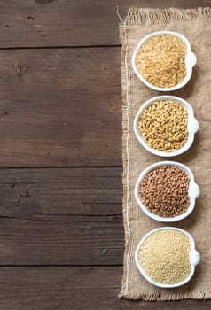 Cereals in bowls border on wooden background