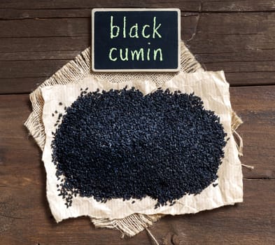 Plie of Nigella sativa or Black cumin on a wooden table