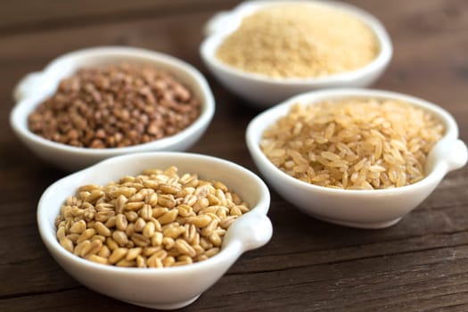 Cereals in bowls close up on wooden background