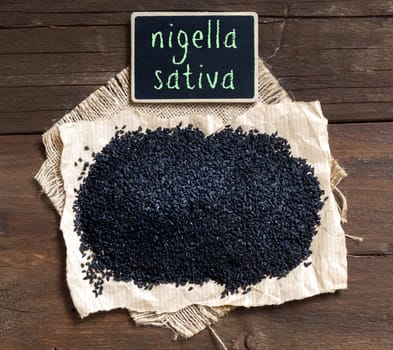 Plie of Nigella sativa or Black cumin on a wooden table