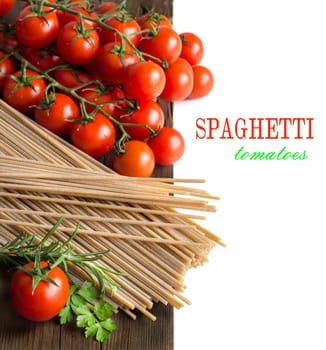 Spaghetti, herbs and tomatoes on old vintage wooden table