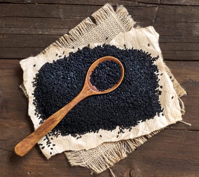 Nigella sativa or Black cumin with a spoon in wood
