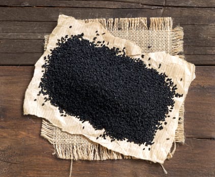 Nigella sativa or Black cumin on a wooden backgound