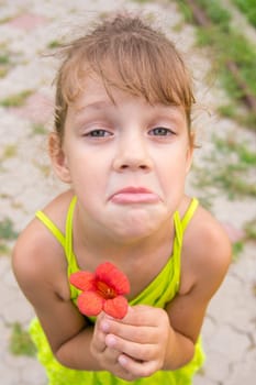 Funny girl with a flower in her hand crouched begging a face looking to the frame