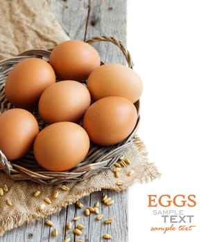 Chicken eggs and wheat on the old wooden table