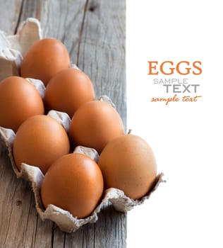 Chicken eggs in the package on the old wooden table