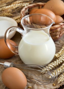 Milk, flour and eggs on the old wooden table
