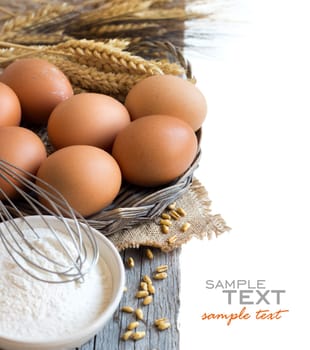 Chicken eggs, wheat and flour on the old wood