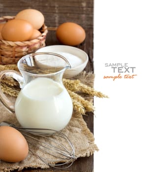 Milk, flour and eggs on the old wooden table