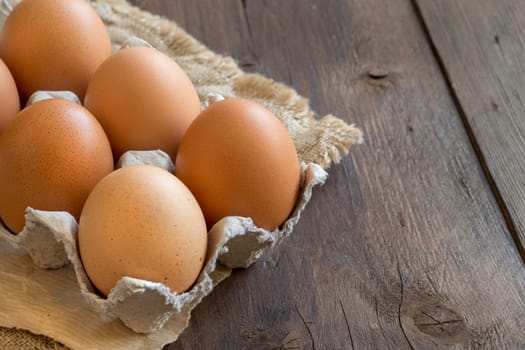 Chicken eggs in the package on the old wooden table