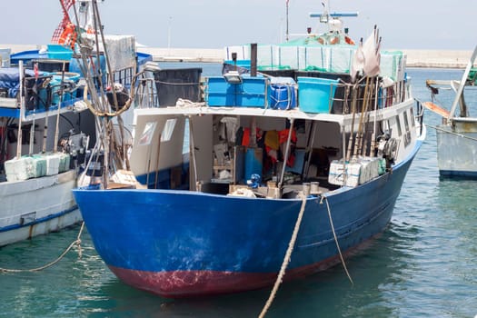 Blue and red fishing boats in harbour, south Italy