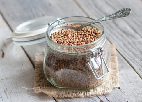 Buckwheat in a glass jar with a spoon
