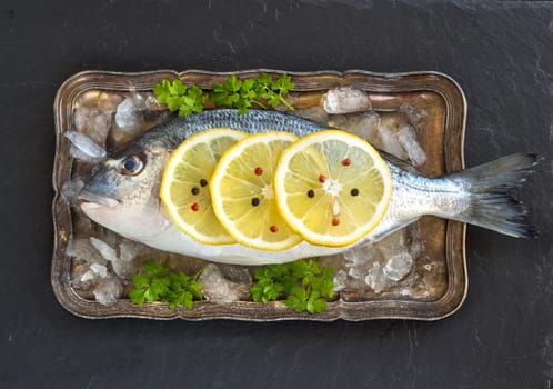 Fresh dorado fish on ice on vintage silver tray