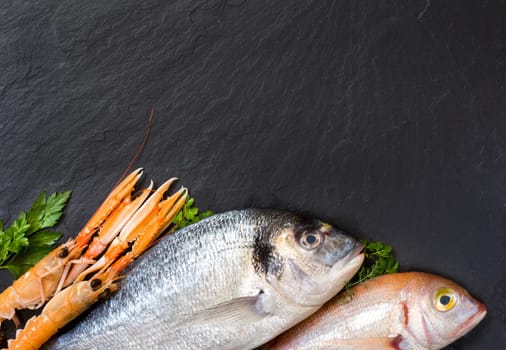 Fresh fish and seafood on dark vintage board