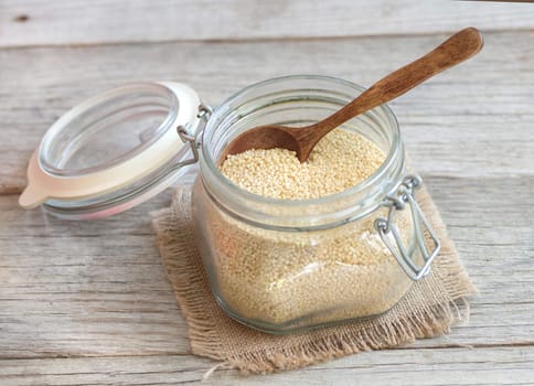 Millet in a glass jar with a spoon