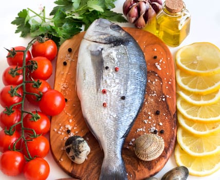 Fresh dorado fish, seafood and vegetables on a white background