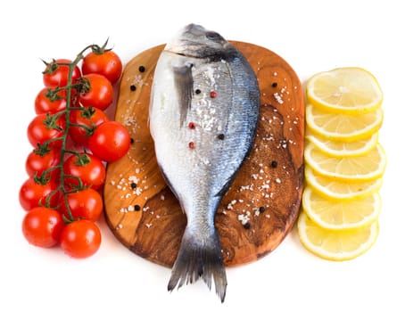 fresh dorado fish, lemon and tomatoes on a white background