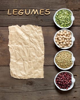 Variety or legumes, word Legumes and paper on a wooden table