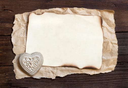 Old paper and heart on the wood background