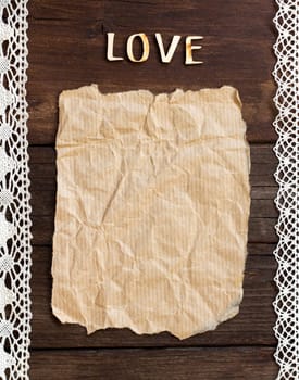 Old paper and word Love with lace borders on the wood background