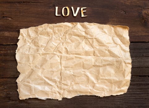 Word love and paper on old wooden background