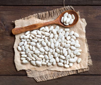 White beans with a spoon on a wooden background