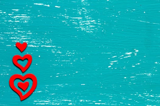 Red hearts on a turquoise wooden background