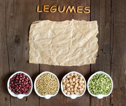 Variety or legumes, word Legumes and paper on a wooden table