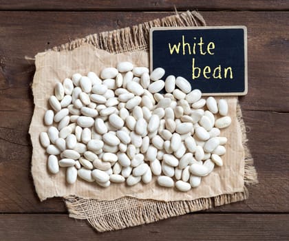 White beans with a small chalkboard on wood