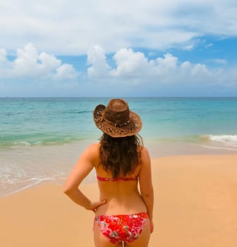 Young woman with hat on sand beach