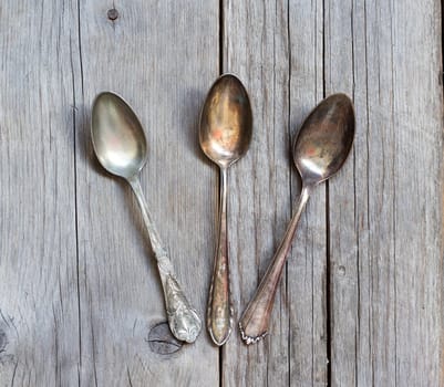 Vintage spoons with patina on old wooden table