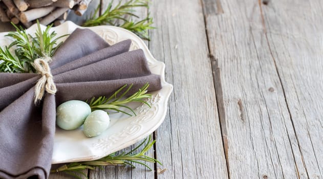 Easter table setting with eggs and rosemary