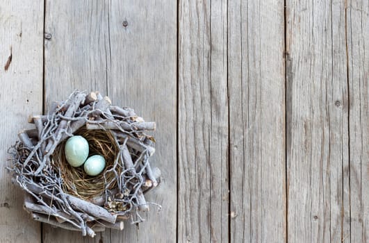 Easter eggs in nest on wood - rustic background