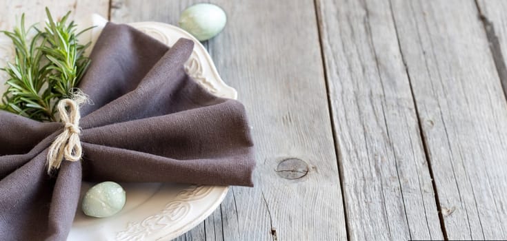 Easter table setting with eggs and rosemary