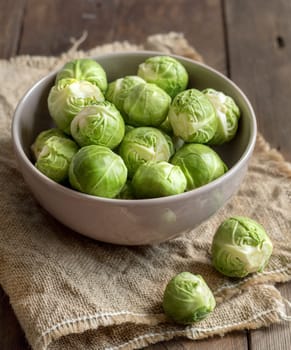 Brussels sprouts in a bowl on burlap on a wooden table