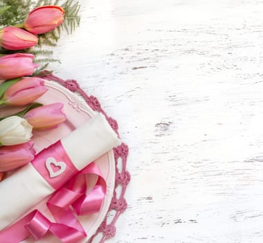 Festive wedding table setting with pink tulips and ribbon