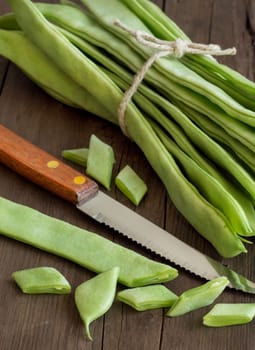 Piattoni green beans with knife on the old wooden table