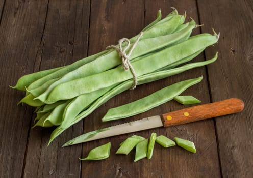 Piattoni green beans with knife on the old wooden table