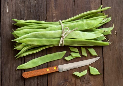 Piattoni green beans with knife on the old wooden table